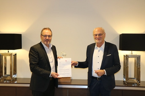 Landesbeauftragter Franz-Josef Sickelmann (rechts) überreicht Bürgermeister Helmut Knurbein (links) den Förderbescheid über 
3,38 Millionen Euro. © Stadt Meppen